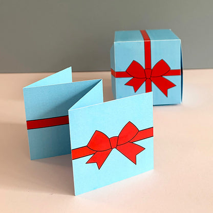 Blaue Klappkarte mit Schleifenmotiv und passende Gutscheinbox – DIY Druckvorlage für persönliche Wertgutscheine.