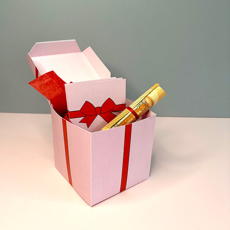 Geöffnete rosa Gutscheinbox mit Schleifenmotiv, Klappkarte und dekorativem Füllpapier