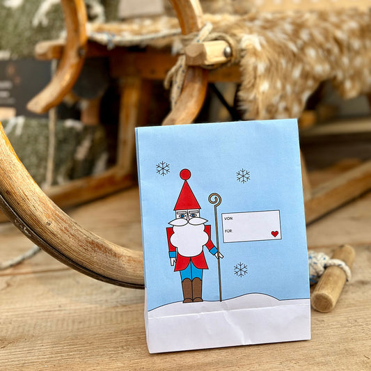 Blaue Nikolaus-Tüte mit Schnee-Illustration als schnelle Bastelidee – DIY-Vorlage der Gutschein-Werkstatt.